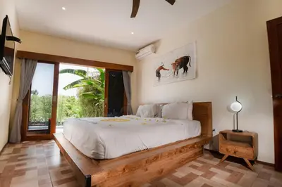 a bedroom with a large bed and a window at Villa Kartini - Two Bedrooms in Legian