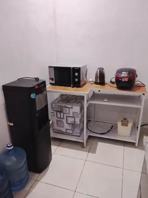 a desk with a microwave and a computer on it at Kuta Grace house Bali in Kuta