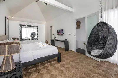a bedroom with a bed and a hanging chair at Villa Stella Belle Seminyak in Seminyak