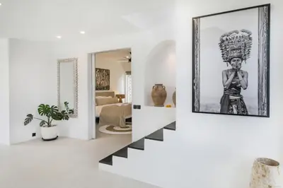 a living room with a staircase and a picture of a woman at Villa Stella Belle Seminyak in Seminyak