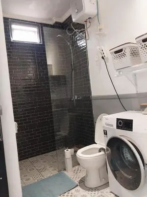 a bathroom with a washing machine and a toilet at Villa 1 Kavi minimalis 1 Kamar di Sanur in Sanur