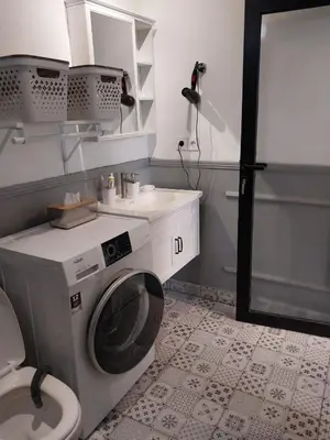 a bathroom with a washing machine and a toilet at Villa 1 Kavi minimalis 1 Kamar di Sanur in Sanur