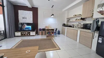 a living room with a tv and a kitchen at Villa 1 Kavi minimalis 1 Kamar di Sanur in Sanur