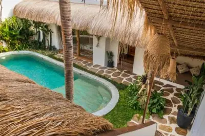 a resort with a swimming pool and a straw umbrella at Adena Modern Paradise 3 BR Private Pool Villa in Kerobokan