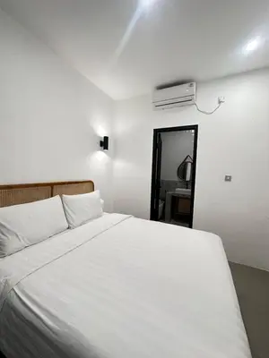 a bedroom with a white bed and a air conditioner at Della Solea Seminyak in Seminyak