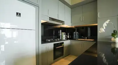 a kitchen with gray cabinets and a black oven at Mahita Garden Villa 3 Bedroom with Amazing view in Jimbaran