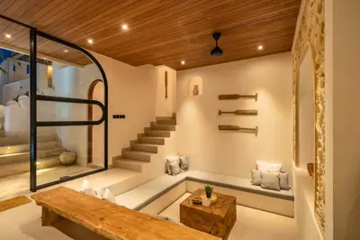 a living room with a staircase and a bench at Omarosa Stunning 3 BR Private Pool Villa in Kerobokan