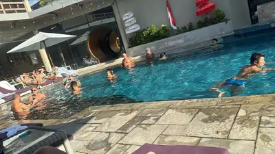 a group of people in a swimming pool at Joand Skyline in Seminyak