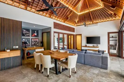 a dining room with a table and a couch at Monique 3 BR Private Pool Villa in Seminyak