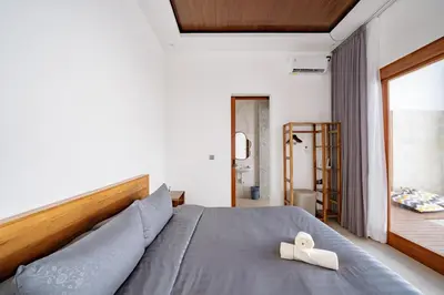 a bedroom with a large bed with a wooden headboard at Il Petrucino Villa by Damaresa in Nusa Dua