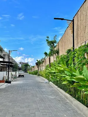 a cobblestone street next to a fence with plants at Casa Danasa, secure and serene Villa at the heart of Seminyak with 24hr One Gate Security in Seminyak