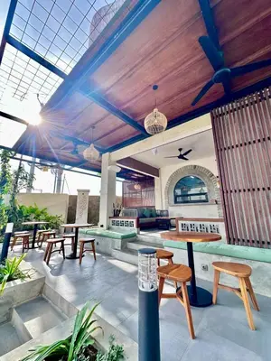 a patio with picnic tables and benches and a roof at Casa Danasa, secure and serene Villa at the heart of Seminyak with 24hr One Gate Security in Seminyak