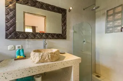 a bathroom with a stone sink and a shower at Villa emma, 2 bed with pool table & private pool in Seminyak