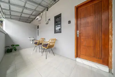 a room with chairs and a wooden door at Cozy Mezzanine Near Airport & Jimbaran Beach in Ngurah Rai International Airport