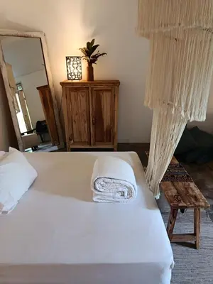 a bedroom with a large white bed and a mirror at Gusti Ayu Private Bali House - 2 Bedrooms near Canggu & Seminyak in Kerobokan