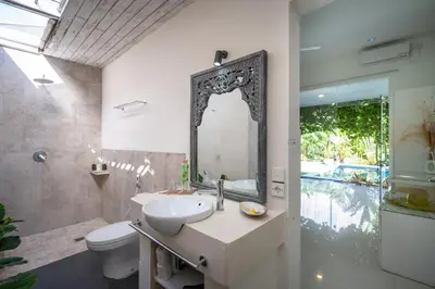 a bathroom with a sink and a toilet and a mirror at Villa 888 Eat Shop Play - 3BR Private Pool Oberoi in Seminyak