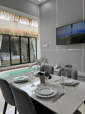 a dining room with a table with chairs and a tv at Ametys 1 Villa - Cozy 2BR Villa with Private Pool & Prime Seminyak in Seminyak