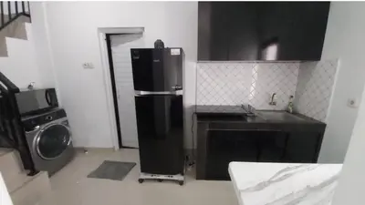 a kitchen with a refrigerator and a washing machine at Chandra's house in Pesanggaran