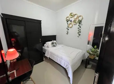 a bedroom with a bed and a black cabinet at Chandra's house in Pesanggaran