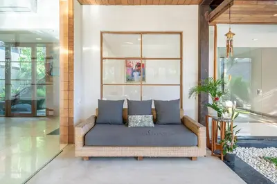 a couch sitting in a room with a window at Lux Ayuni Big Modern 2BR Designer Villa Berawa in Canggu