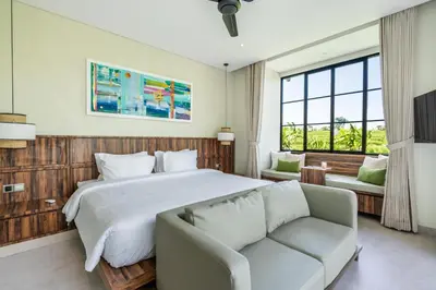 a bedroom with a large bed and a couch at Villa Rice Kerobokan in Kerobokan