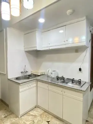 a kitchen with white cabinets and a sink at The Beach Residence at Jayakarta Resort Bali in Seminyak