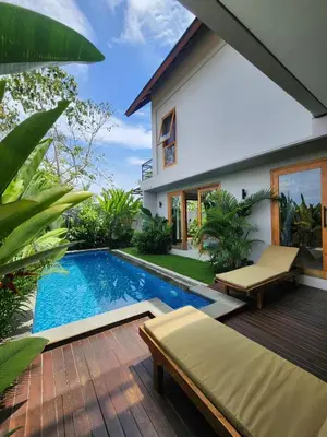 a backyard with a swimming pool and a house at Best Villa in Jimbaran
