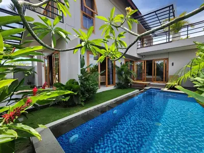 a villa with a swimming pool in front of a house at Best Villa in Jimbaran