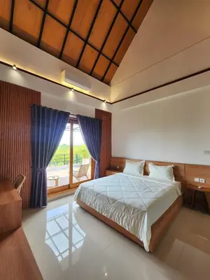 a bedroom with a bed and a large window at Best Villa in Jimbaran