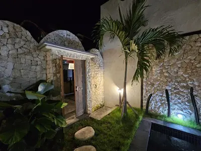 a house with a palm tree in front of a building at Mediterranean Villa Sanur Beach in Sanur
