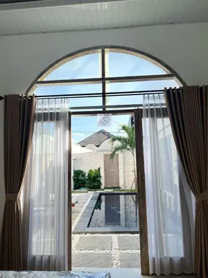 an arched window with a view of a pool at Mediterranean Villa Sanur Beach in Sanur