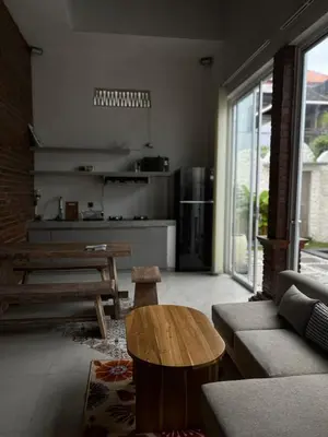 a living room with a table and a kitchen at Mediterranean Villa Sanur Beach in Sanur