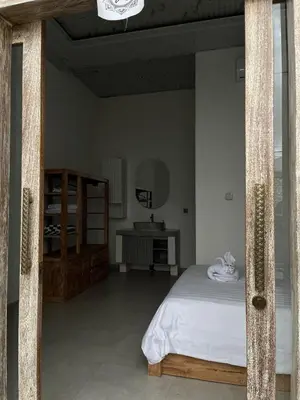 a bedroom with a white bed and a table at Mediterranean Villa Sanur Beach in Sanur