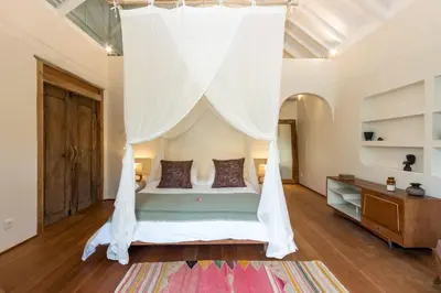 a bedroom with a bed with a canopy at Villa Anicca - Family-Friendly 4BR Villa Umalas With Private Pool And Rooftop Lounge in Canggu