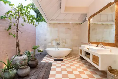 a bathroom with a tub and two sinks and potted plants at Villa Anicca - Family-Friendly 4BR Villa Umalas With Private Pool And Rooftop Lounge in Canggu