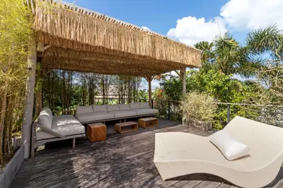 a pergola with benches and tables on a patio at Villa Anicca - Family-Friendly 4BR Villa Umalas With Private Pool And Rooftop Lounge in Canggu