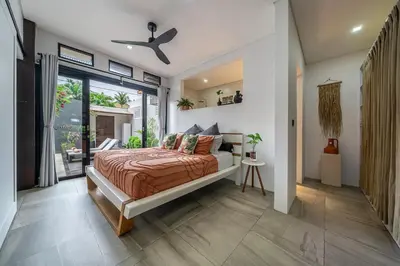 a bedroom with a bed and a large window at Villa 121 - Modern 1BR Villa Near Batu Belig Beach in Seminyak