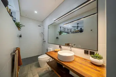 a bathroom with a sink and a toilet and a mirror at Villa 121 - Modern 1BR Villa Near Batu Belig Beach in Seminyak