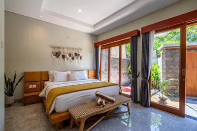 a bedroom with a large bed and a large window at Semar Villa, a cozy studio Villa with a Private Pool, Bali in Legian