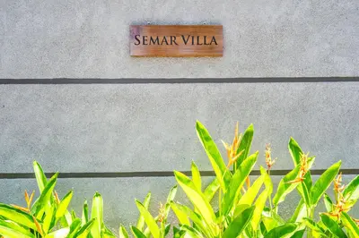 a sign on the side of a building with green plants at Semar Villa, a cozy studio Villa with a Private Pool, Bali in Legian