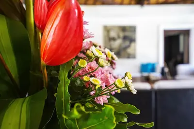 a vase with a red flower and some flowers at Superb and Elegant 3-Bedroom Villa Close to the Beach in Seminyak