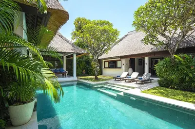 a villa with a swimming pool next to a house at Superb and Elegant 3-Bedroom Villa Close to the Beach in Seminyak