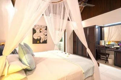a bedroom with a white bed with drapes at Superb and Elegant 3-Bedroom Villa Close to the Beach in Seminyak