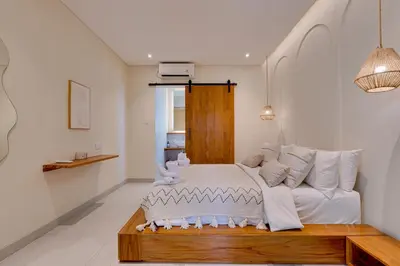 a bedroom with a white bed and a couch at Private 3BR Villa Sweetie with Pool Seminyak in Seminyak