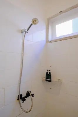 a shower with a shower head in a bathroom at Villa Beji Ayu Seminyak - 2 Bedroom Private Pool in Seminyak