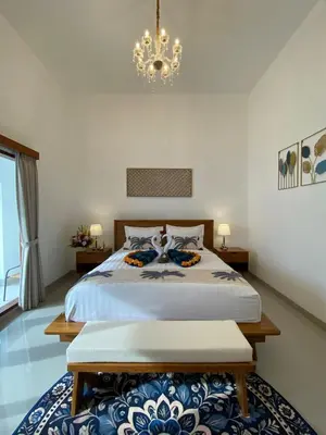 a bedroom with a bed and a chandelier at Arts Ebena Villa Two-Bedroom Private Pool Kuta in Seminyak