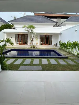 a villa with a swimming pool in front of a house at Arts Ebena Villa Two-Bedroom Private Pool Kuta in Seminyak