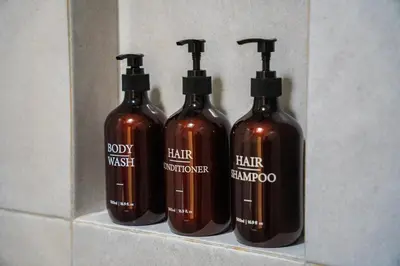 three bottles of hair shampoo sitting on a shelf at Satori Villa Umalas in Canggu