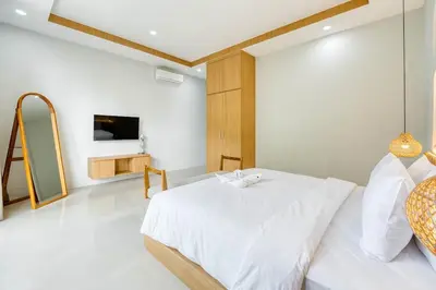 a white bedroom with a bed and a tv at Villa Tébu 3 BR Brand New Villa in Umalas in Kerobokan