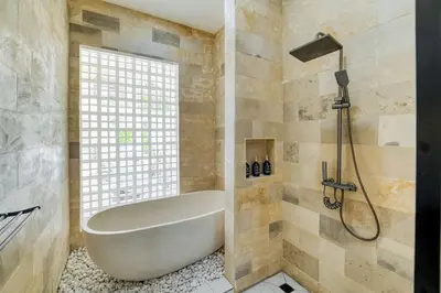 a bathroom with a bath tub and a window at Villa Tébu 3 BR Brand New Villa in Umalas in Kerobokan